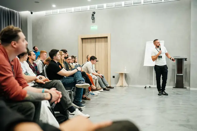 Слушатели IT Talk by Sber и Денис Бугров у экрана