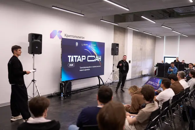 Денис Бугров у экрана с названием ТАТАРСАН, зал слушает